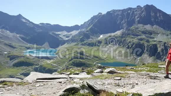 在蓝湖、高山峰和冰川的田园山景中，女子徒步旅行。 阿尔的夏日冒险