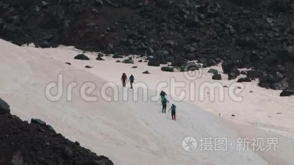 人们爬上游客在雪山山坡上散步视频