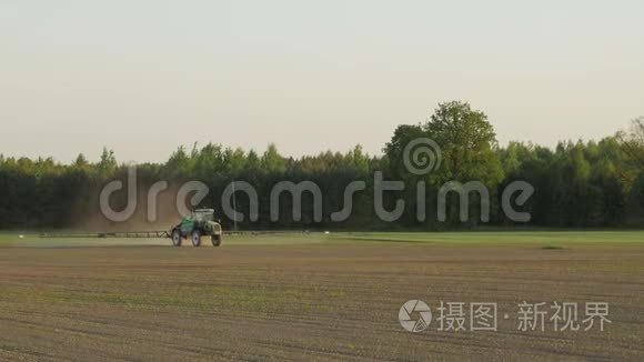 拖拉机用化学物质喷洒农田，以保护作物免受杂草和害虫的侵害。