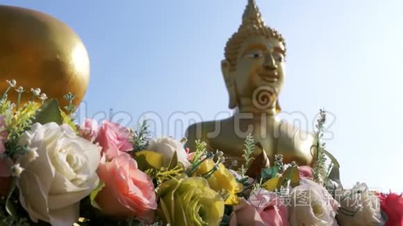 在泰国寺庙里的一个大金佛背景上的花。 帕塔亚