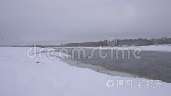 雪中一条冬季河流的景观，背景是一片雪林，4K，天然