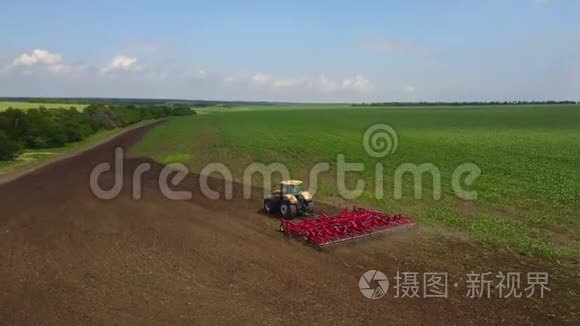 空中跟踪拍摄拖拉机播种，在田间播种农作物。 从上面看