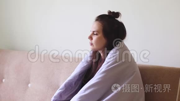 生病的年轻女子坐在家里，喉咙痛，咳嗽。