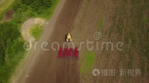 空中跟踪拍摄拖拉机播种，在田间播种农作物。 从上面看