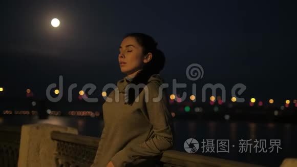 运动女孩在夜城慢跑后休息。