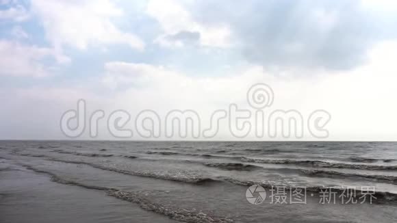 以波浪和多云天空为背景的海滨全景。 乌云密布的暴风雨海和波浪在缓慢的运动。 海洋和海洋