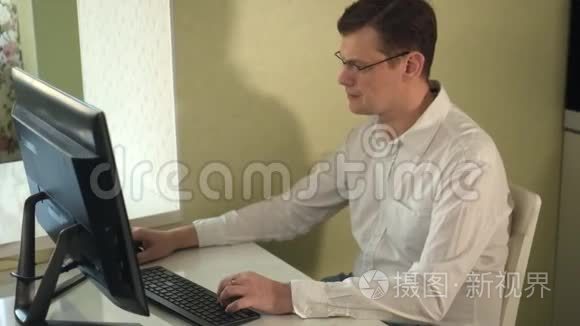 戴眼镜的严肃男子在电脑上工作视频