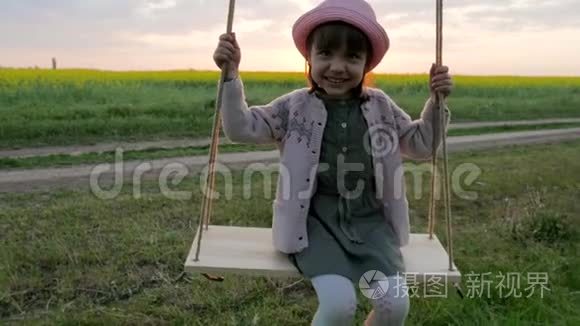 女孩子在树枝上荡秋千，小女孩骑着秋千，在公园里休息，快乐的孩子在新鲜空气中玩耍