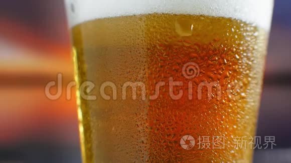 特写慢镜头：冷啤在一个杯子里大滴和气泡在啤酒里..