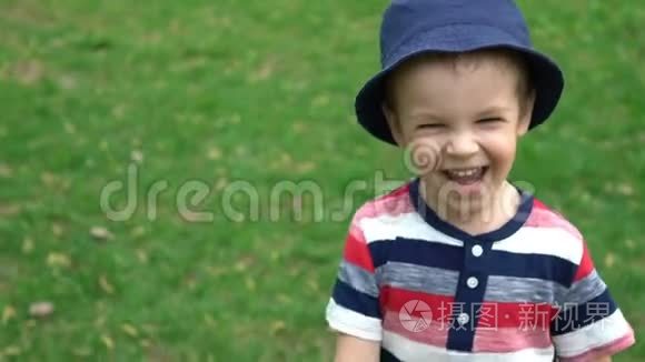 快乐的男孩在公园的草地上奔跑