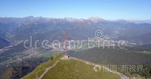 在一个晴朗而蓝色的日子里，可以看到塞里亚纳山谷和奥罗比阿尔卑斯山的无人机空中景色。 山顶的十字架