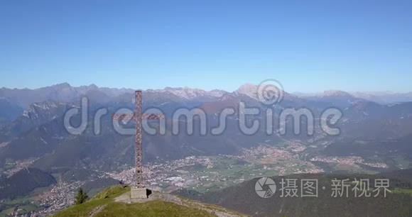 在一个晴朗而蓝色的日子里，可以看到塞里亚纳山谷和奥罗比阿尔卑斯山的无人机空中景色。 山顶的十字架