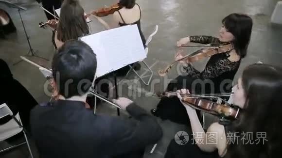 四位小提琴手在大厅里演奏音乐