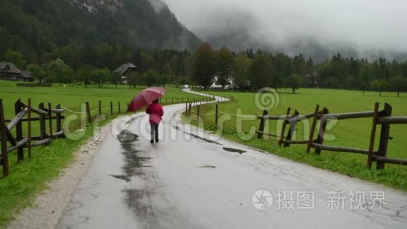 小女孩在乡间小路上雨中散步视频