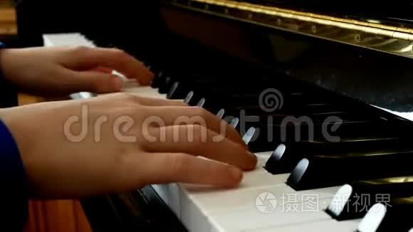 孩子弹钢琴。 关闭侧视年轻的手和手指在钥匙上播放一首歌。