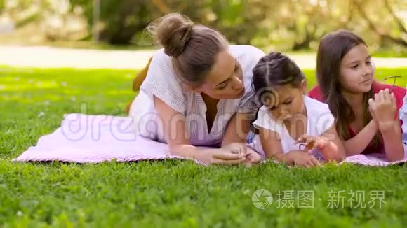 一家人躺在夏日公园的野餐毯上视频