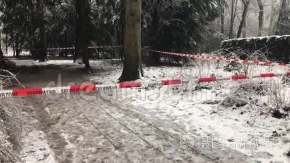 冬天，森林里的一个犯罪现场前有很多降雪的消防队路障