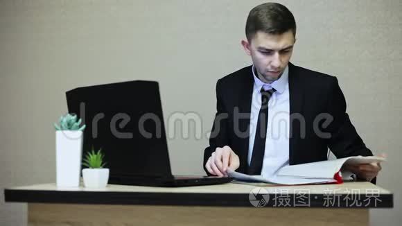 年轻的商人在办公室工作，在笔记本电脑上打字。