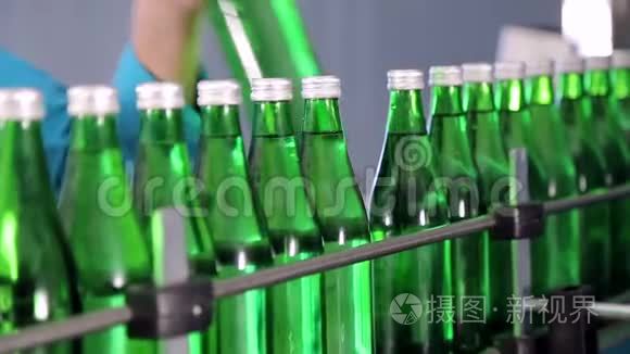 生产线一名员工为矿泉水擦拭绿色玻璃瓶.. 关门