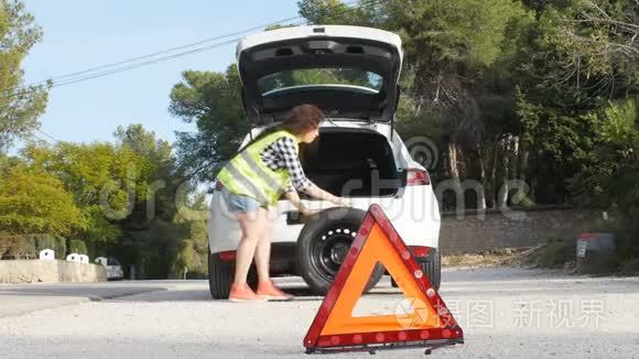 汽车故障。 女人在路上换轮胎