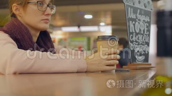 女人用智能手机拿着纸杯咖啡