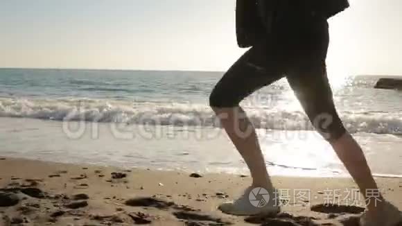 女人穿着跑鞋的腿，沿着海滨海洋奔跑。 在海边奔跑