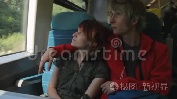 年轻漂亮快乐的时髦夫妇坐在火车旁，谈论着他们的生活，笑着开玩笑。 暑假假期