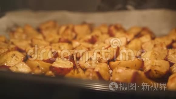 烤土豆与迷迭香，大蒜，胡椒和百里香在烤箱。 健康素食饮食或烹饪食谱概念4K页。