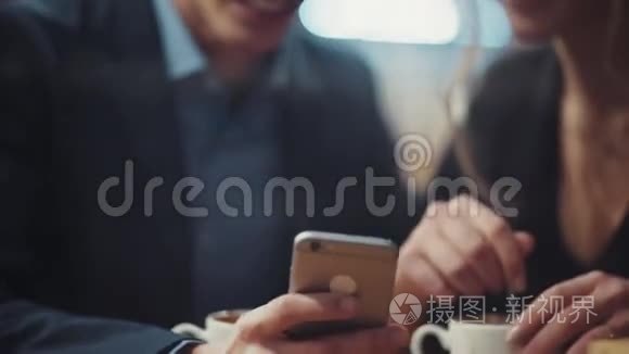 一个男人在他的智能手机上给他的女朋友看照片，他们在约会时互相嘲笑和享受。