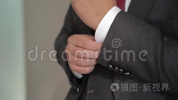 年轻人戴上袖扣。 为庆祝活动、商务会议或婚礼穿衣服