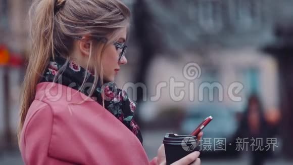 旋转观看一个华丽时尚的女孩拿着一杯咖啡，用她的手机上网。 商务