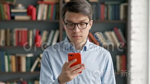 年轻人用智能手机画像笑站在图书馆社交媒体上搞笑