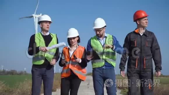 工程师在公路上靠风力涡轮机行走