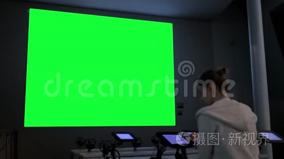 女人看着大空白绿色屏幕-色度关键概念
