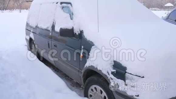 被雪覆盖的汽车，在严重的冬季风暴下。 在雪下的院子里。