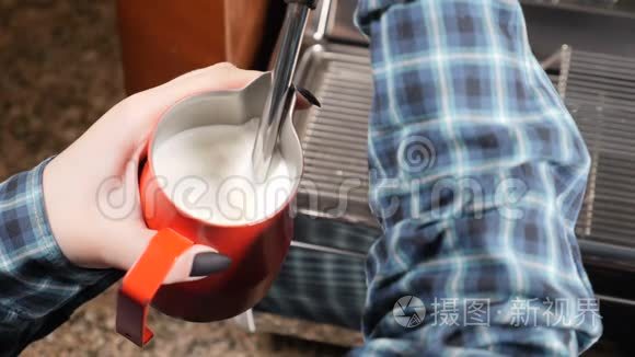 咖啡屋。 咖啡师做卡布奇诺。 做浓咖啡和蒸汽牛奶。 咖啡师正在准备热牛奶泡沫。 慢慢