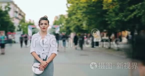 穿着现代服装的女孩看着摄像机站在城市街道上的时间流逝