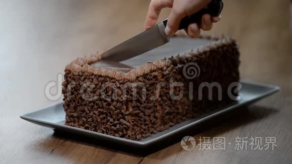 一个男人正在切巧克力蛋糕