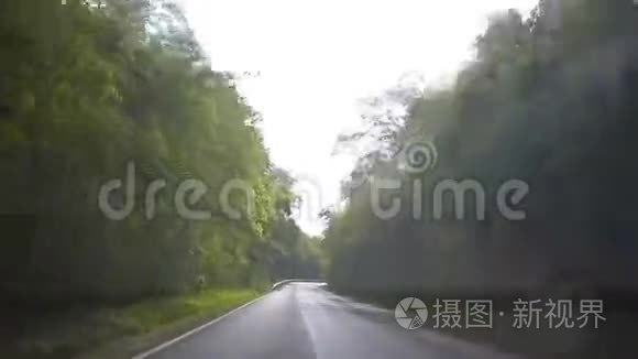 在雨中驾驶着挡风玻璃雨刷在乡村道路上。