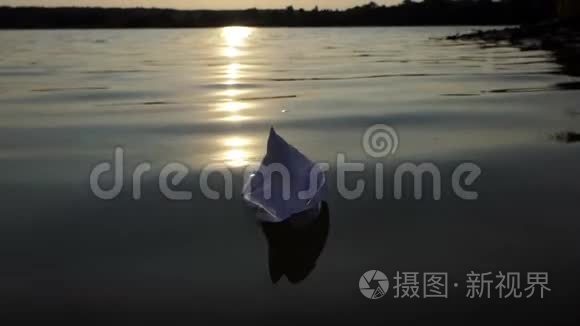 夕阳西下，一艘白色的纸船漂浮在湖水中