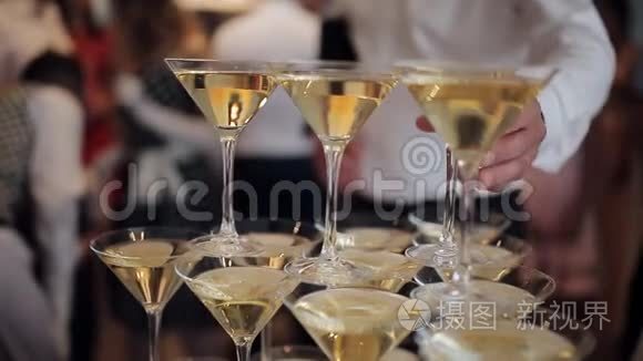 在聚会上，客人们`手拿酒杯喝着冒泡的葡萄酒。 眼镜是在金字塔里建造的。 无法辨认