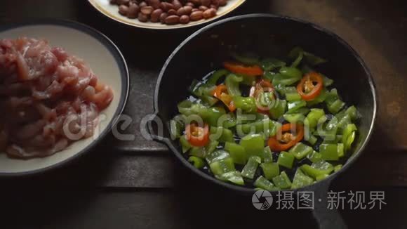 鸡块，豆子。胡椒和辣椒在煎锅里特写。视频