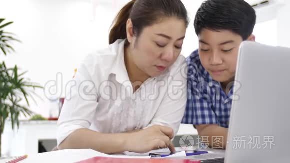 母亲和儿子玩和看智能手机，多莉拍摄了快乐的亚洲家庭在家的笑脸。