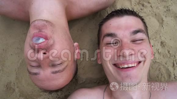 还有两个年轻人躺在海滩上，嚼口香糖，吹泡泡，对着镜头微笑