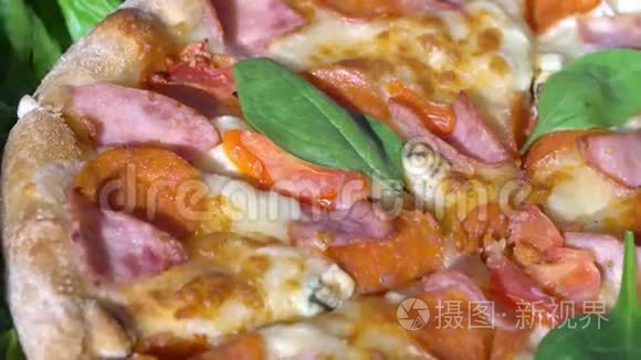 快关门。 带有西红柿和奶酪背景的披萨在厨房餐桌上旋转