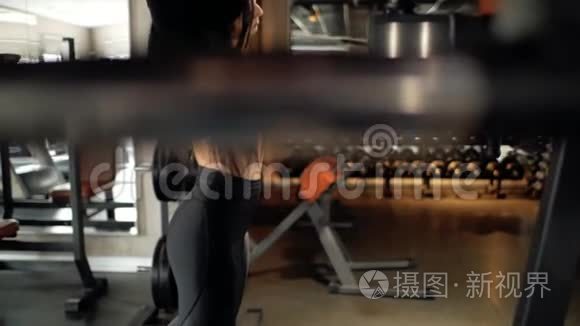 运动白种人黑发女孩在健身房做伸展运动。 参加健身运动的女人