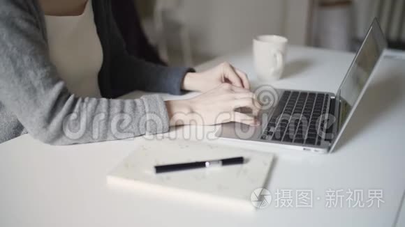 坐在桌子上的女人手在键盘上打字