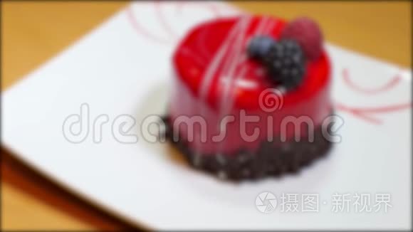 一个漂亮的红色单份蛋糕的照片放在一个白色的盘子里，镜头聚焦并再次失去焦点