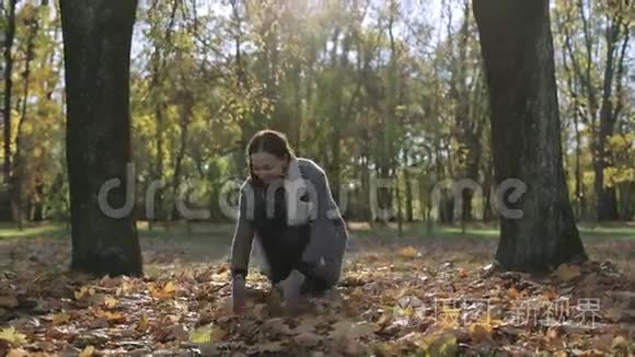 快乐的女人微笑着，在秋天扔树叶。