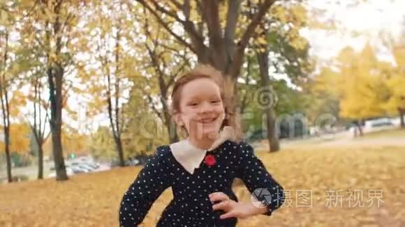 肖像可爱的小女孩，卷发，穿着圆点花纹的裙子穿过公园里的秋天小巷